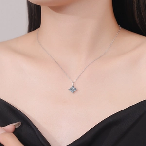 Gros plan d'un collier en argent s925 avec pendentif carré en moissanite bleue sur un mannequin