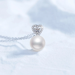 S925 silver heart necklace with moissanite and round freshwater pearl on icy background