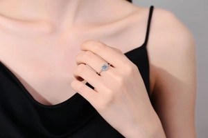 Close-up of a s925 silver halo ring with a round moissanite stone on a model's finger