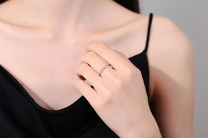 Detail of s925 silver twisted ring band with sparkling pavé moissanite on female hand