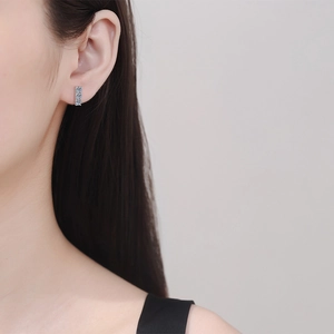 Elegant S925 sterling silver studs with three sparkling moissanite stones on model