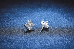 Macro view of S925 sterling silver four-leaf clover stud earrings with sparkling moissanite