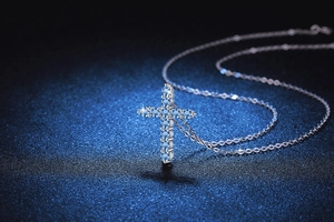 Close-up of sparkling blue moissanite cross pendant with polished S925 silver chain