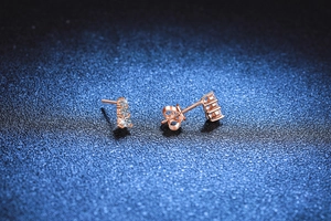 Close-up of rose gold 925 sterling silver stud earrings with three vertical Moissanite stones