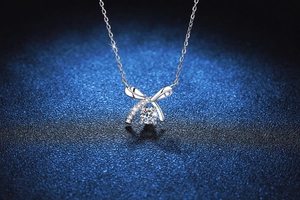 Vue macro du collier avec pendentif nœud en argent S925 et pierre de moissanite brillante