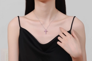Close-up of S925 silver necklace with cross pendant featuring pink moissanite on model