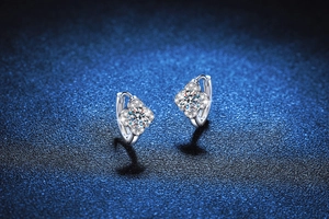 Dettaglio orecchini a quadrifoglio in argento S925 con moissanite su sfondo luccicante