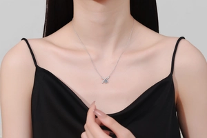 Gros plan du collier nœud en argent S925 avec une pierre de moissanite bleue étincelante