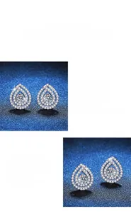 Macro view of pear-cut moissanite earrings with halo setting and polished silver finish