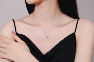 Close-up of S925 sterling silver necklace with a 1-carat moissanite pendant on a model