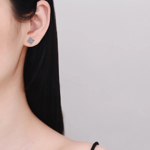 Elegant S925 sterling silver four-leaf clover moissanite stud earrings worn by a model