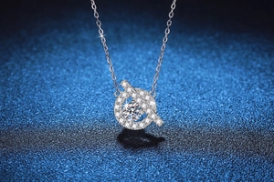 Macro detail of S925 silver necklace with 1 carat moissanite pave pendant on blue background