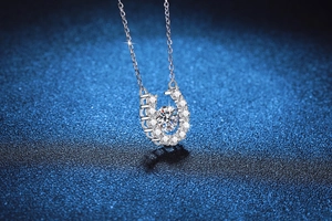 Macro shot of silver horseshoe pendant with floating moissanite diamond on starry background