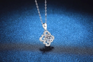Macro shot of silver four-leaf clover pendant with sparkling 1 carat round moissanite