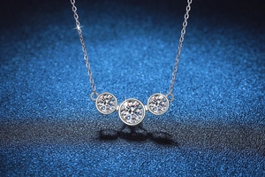 Vue macro du collier trois pierres en Moissanite 2ct avec brillance de feu éclatante
