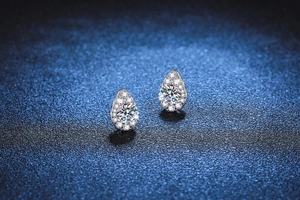 Macro shot of S925 silver pear-shaped stud earrings with round moissanite halo setting