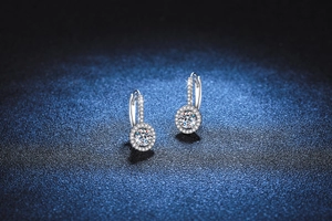 Close-up of S925 sterling silver halo earrings with round moissanite and pave accents