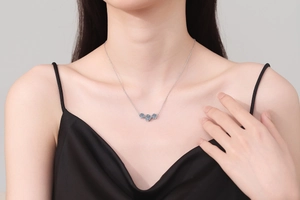 Gros plan d'un collier en argent S925 avec trois pierres bleues porté par un mannequin