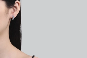 Close-up of S925 sterling silver hoop earrings with pavé set moissanite stones on model