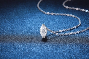 Macro d'un pendentif en Moissanite taille marquise avec chaîne en argent 925 sur bleu