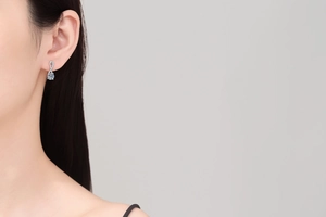 Close-up of S925 sterling silver figure-eight drop earrings with moissanite on model