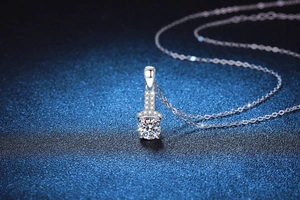 Macro view of a round cut moissanite pendant with micro-pave diamonds on silver chain