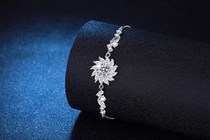 Macro detail of silver sunflower bracelet with sparkling moissanite petals on a dark base