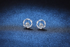 Close-up of S925 sterling silver Mobius earrings with 1 carat moissanite on dark background