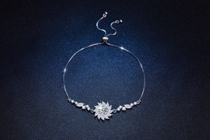 Macro detail of adjustable silver box chain bracelet with sparkling moissanite sunflower charm