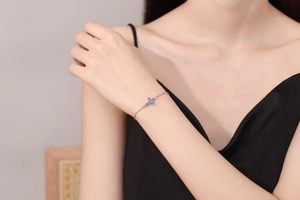 Close-up of S925 sterling silver cross bracelet featuring sparkling blue moissanite stones