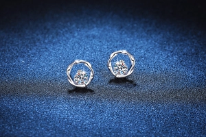 Macro shot of silver Moissanite stud earrings featuring twisted Mobius circle design