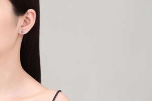 Detailed close-up of double-set D-color moissanite sterling silver earrings on ear