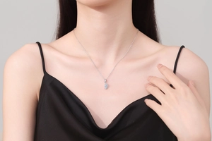 Close-up of S925 silver necklace featuring a marquise-cut moissanite pendant on a model
