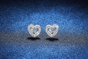 Close-up of S925 sterling silver heart earrings with Moissanite stones on starry background