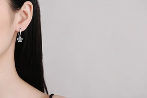 Detail view of S925 sterling silver ear hooks with flower moissanite stones on model