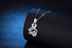 Close-up of 1ct moissanite pendant with interlocking silver curves on a jewelry stand