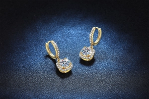 Macro shot of 14k gold plated moissanite earrings with halo setting on blue background