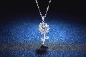 Detailed close-up of a sparkling silver sunflower pendant set with shimmering moissanite