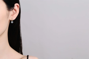 Detail of 1 carat moissanite dangling earrings with 925 silver fringe on a female model