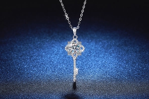 Macro shot of silver four-leaf clover key pendant with high-sparkle moissanite stones