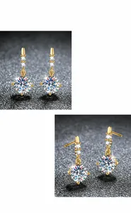 Detail view of moissanite earrings with 1 carat stones and dangling gold finish chain