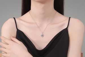 Close-up of heart-shaped silver moissanite pendant worn by a model on an O-chain