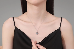 Gros plan du collier coeur en argent S925 avec couronne porté par un mannequin