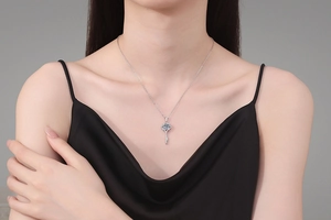 Detail of a sparkling S925 silver clover key pendant with 1ct moissanite on a model