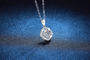 Macro shot of S925 silver four-leaf clover pendant with 1ct moissanite on blue background