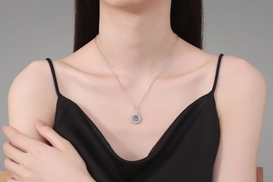Close-up of S925 sterling silver crown dancing moissanite pendant on female model neck