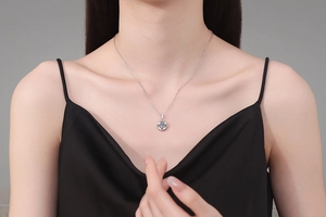 Close-up of S925 sterling silver four-leaf clover necklace with 1ct blue moissanite on model