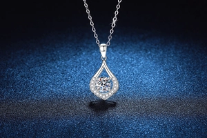 Macro view of S925 silver teardrop pendant with 1ct round moissanite and pavé accents