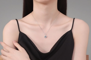 Close-up of s925 sterling silver square moissanite pendant worn on model with silk dress