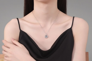 Close-up of S925 sterling silver necklace with a sparkling round moissanite stone on model